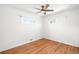 Minimalist bedroom with hardwood floors, white walls, two windows, and ample natural light at 1757 S Elm St, Denver, CO 80222