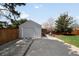 A detached garage is nestled beside a fenced yard and next to a small seating area at 1757 S Elm St, Denver, CO 80222