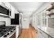 Bright kitchen featuring white cabinets, stainless steel appliances, granite counters, and hardwood floors at 1757 S Elm St, Denver, CO 80222