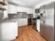 Updated kitchen features white cabinets, stainless steel appliances, granite countertops, and stylish backsplash at 1757 S Elm St, Denver, CO 80222