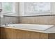 Bathroom soaking tub with tile surround and large window at 4915 Sage Brush Dr, Broomfield, CO 80023