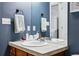 Stylish bathroom featuring a granite countertop, modern sink, and a soothing blue wall color at 4915 Sage Brush Dr, Broomfield, CO 80023