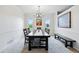 Bright dining room with a rustic wood table, chandelier, and sunlit windows at 4915 Sage Brush Dr, Broomfield, CO 80023