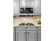 Gourmet kitchen featuring granite counters, tile backsplash, cooktop and microwave at 4915 Sage Brush Dr, Broomfield, CO 80023
