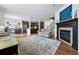 Open concept living room view of kitchen, hardwood floors, fireplace, and staircase at 4915 Sage Brush Dr, Broomfield, CO 80023