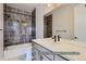 Modern bathroom with gray tile, vanity, and a bathtub with shower at 9752 Canyon Wind Pt, Parker, CO 80138