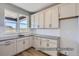 Bright kitchen features white cabinets, gray countertops, stainless steel sink, and backyard view at 9752 Canyon Wind Pt, Parker, CO 80138