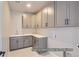 Well-organized laundry room with gray cabinets, quartz countertops, and a sink at 9752 Canyon Wind Pt, Parker, CO 80138