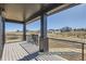 Covered outdoor patio showcases dark pillars and iron railing, offering scenic landscape views at 9752 Canyon Wind Pt, Parker, CO 80138