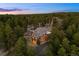 Aerial view of secluded two-story home nestled amongst a dense forest with custom landscaping at 10231 Democrat Rd, Parker, CO 80134