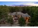 Aerial view of a luxurious home nestled among mature pine trees and professionally landscaped backyard at 10231 Democrat Rd, Parker, CO 80134