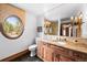 Cozy bathroom with granite vanity, unique oval window, and decorative lighting at 10231 Democrat Rd, Parker, CO 80134