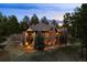 Twilight view of the beautiful stone and siding two-story home with balconies and mature trees surrounding it at 10231 Democrat Rd, Parker, CO 80134