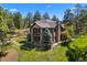 Secluded two-story home with stone and siding exterior, featuring an outdoor patio and lush surroundings at 10231 Democrat Rd, Parker, CO 80134