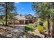Craftsman home featuring stone accents, a three-car garage, landscaped garden, and a charming front entryway at 10231 Democrat Rd, Parker, CO 80134
