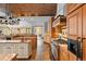 Spacious kitchen with custom cabinets, stone floors, brick ceiling, and stainless steel appliances at 10231 Democrat Rd, Parker, CO 80134