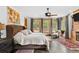Main bedroom featuring a fireplace, ceiling fan, stone floors, and a view of the surrounding trees at 10231 Democrat Rd, Parker, CO 80134