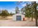 Modern outbuilding with a large garage door, red accent door, and ample space for storage or workshop at 10231 Democrat Rd, Parker, CO 80134