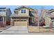 Charming two-story home featuring a tan and green exterior, a two car garage, and well-kept lawn at 10597 Casper St, Parker, CO 80134