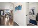 Hallway showcasing modern wall art, leading to a well-lit kitchen and a glimpse of a convenient bathroom at 10597 Casper St, Parker, CO 80134