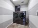 Modern laundry room with front-load washer and dryer set, sleek cabinetry, and stylish striped walls at 10597 Casper St, Parker, CO 80134