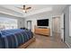 Bright main bedroom featuring a tray ceiling, ceiling fan, and a flat screen tv at 10597 Casper St, Parker, CO 80134