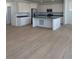 Bright, open-concept kitchen with an island, stainless steel appliances, and modern white cabinets at 6657 E 149Th Dr, Thornton, CO 80602