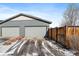 Two-car garage with driveway and wooden fence at 9094 E 58Th Dr, Denver, CO 80238