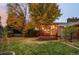 A house with a large backyard with trees and a wooden deck with an overhang that is decorated with string lights at 1800 S Niagara Way, Denver, CO 80224
