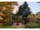Cozy backyard with a fire pit and comfortable seating nestled among lush landscaping and string lights at 1800 S Niagara Way, Denver, CO 80224