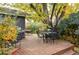 Cozy backyard deck with multiple seating areas surrounded by lush landscaping and mature trees at 1800 S Niagara Way, Denver, CO 80224