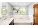Bright bathroom features a soaking tub with a window view, complemented by a modern vanity at 1800 S Niagara Way, Denver, CO 80224