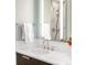 A close-up of the bathroom sink and vanity with white marble countertop and mirror at 1800 S Niagara Way, Denver, CO 80224