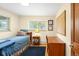 Well-lit bedroom featuring a wooden bed frame, desk, hardwood floors, and natural light from the windows at 1800 S Niagara Way, Denver, CO 80224