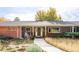 Charming home featuring a covered front porch, landscaped yard, and inviting walkway to the front door at 1800 S Niagara Way, Denver, CO 80224