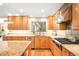 Bright kitchen showcasing wood cabinets, stainless appliances, granite counters and a window with backyard views at 1800 S Niagara Way, Denver, CO 80224