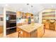 This kitchen boasts custom wood cabinetry, stainless appliances and granite countertops plus an adjacent seating area at 1800 S Niagara Way, Denver, CO 80224