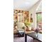 Bright living room featuring a built-in bookshelf, a comfortable armchair, and sliding door to a deck at 1800 S Niagara Way, Denver, CO 80224