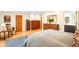 A well-lit main bedroom featuring three wood dressers, hardwood floors, and a rocking chair at 1800 S Niagara Way, Denver, CO 80224