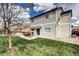 Exterior home view showing a patio, lawn, and partial fenced yard with trees at 10554 Tracewood Cir, Highlands Ranch, CO 80130
