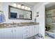 Bathroom with dual sinks, granite countertops, modern vanity, and glass shower at 10554 Tracewood Cir, Highlands Ranch, CO 80130