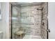 Modern shower with tiled walls, shower seat and glass enclosure in the ensuite bathroom at 10554 Tracewood Cir, Highlands Ranch, CO 80130