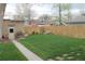 Lush backyard featuring a neatly kept lawn, a wooden fence, and mature trees at 1395 S Josephine St, Denver, CO 80210