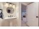 Charming powder room with pedestal sink, round mirror, and adjacent living area at 1395 S Josephine St, Denver, CO 80210