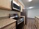 Modern kitchen with stainless steel appliances, granite countertops, and wooden cabinets for ample storage at 50 E Highline Cir # 101, Centennial, CO 80122
