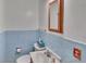 Bright bathroom featuring blue tiling, a white sink, and a toilet with modern fixtures at 4960 S Fox St, Englewood, CO 80110