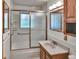 Bathroom featuring a tub with glass doors, a window, a vanity with sink, and updated fixtures at 4960 S Fox St, Englewood, CO 80110