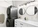 Modern bathroom featuring dual mirrors, modern vanity, and in-unit washer and dryer for convenience at 2261 Blake St # 2G, Denver, CO 80205