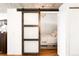 Bedroom entrance with frosted glass barn door, closet, and bedroom with hardwood flooring and overhead lighting at 2261 Blake St # 2G, Denver, CO 80205