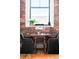 Close up on the dining area featuring exposed brick, natural light and a small wooden table with seating for two at 2261 Blake St # 2G, Denver, CO 80205